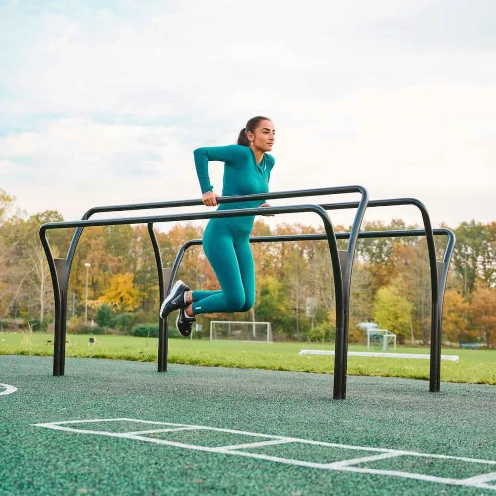 Runner moving across compact soil beside rail fence